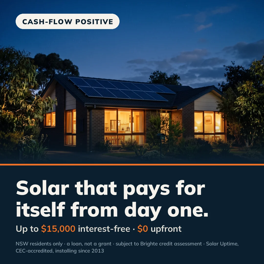 Australian home at dusk with warm interior lights glowing and rooftop solar silhouetted against a navy sky